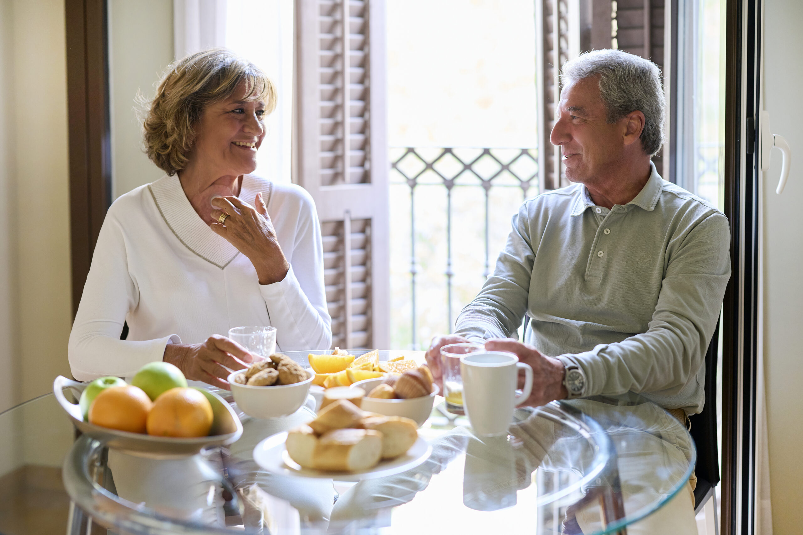 woman with a neck stoma and man talking over kitchen table